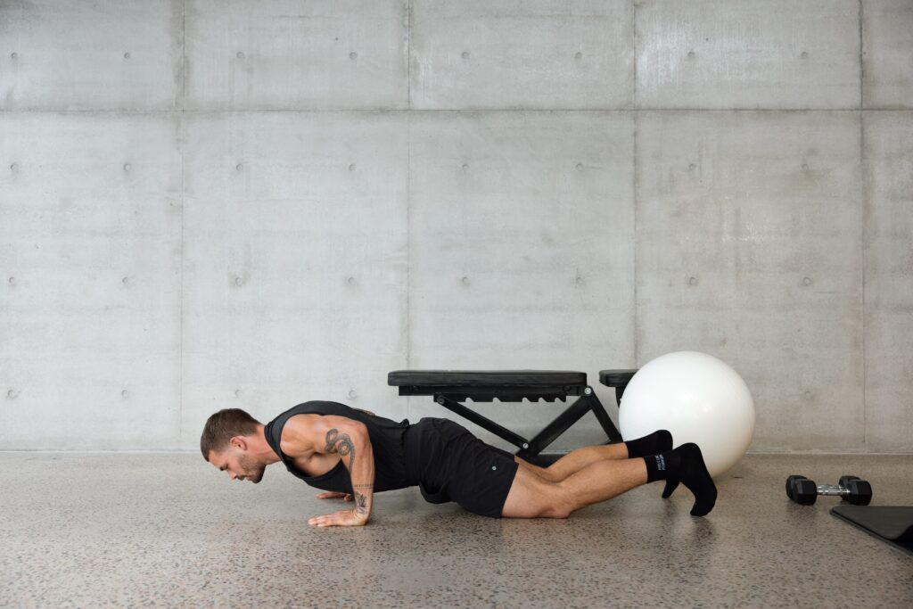 male performing a push up in gym setting